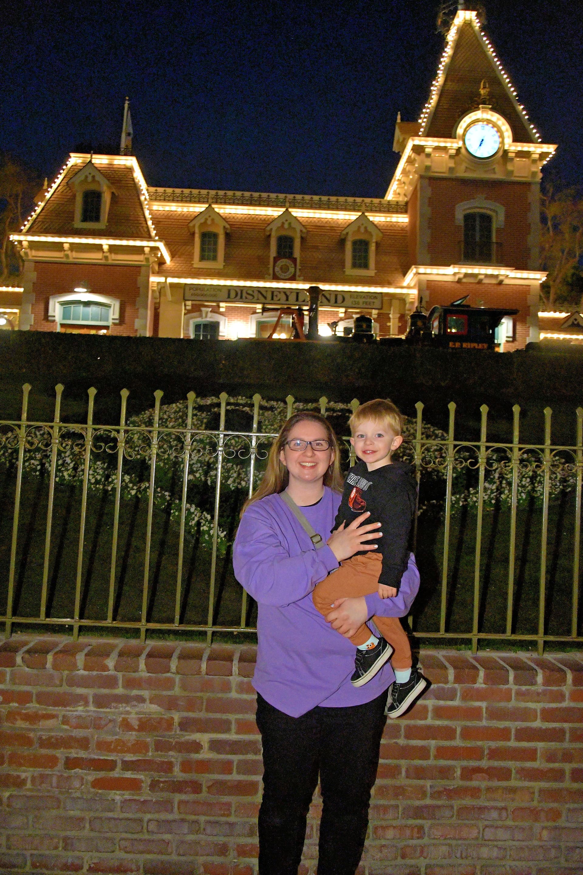 Madison holding her son in front of Disneyland at night
